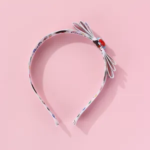Close-up of fabric headband showing cartoon pattern print and multilayered bow detail