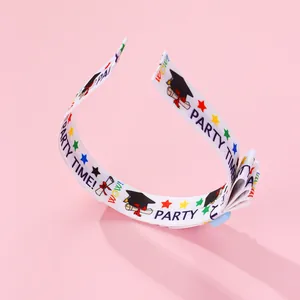 Detailed view of white graduation headband with colorful stars and graduation caps