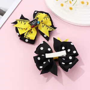 Detail of school bow hair clips with ABC chalkboard and ruler ribbon texture