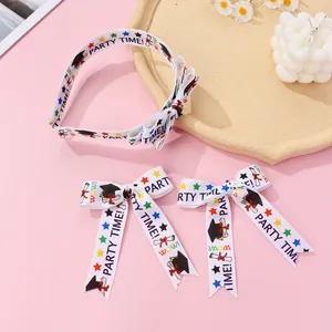 Detail of white bow headband and clips with graduation motifs and party slogans