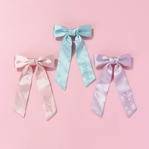 Détail de nœuds à cheveux en soie avec broderie BEST FRIEND FOREVER en tons pastels