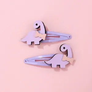 Détail de barrettes dinosaures lavande en feutrine avec petits nœuds mignons