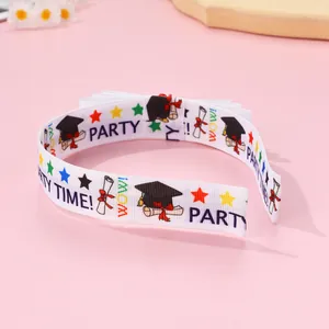 Detail of white graduation headband with black mortarboard and diploma star patterns