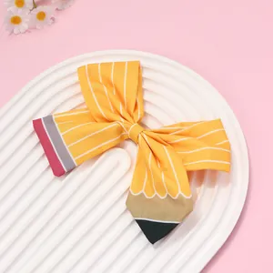 Détail du nœud papillon crayon jaune avec texture en tissu sur plateau blanc