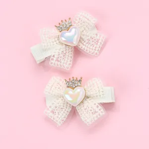 Détail de barrettes en dentelle avec cœur perlé et couronne dorée pour filles