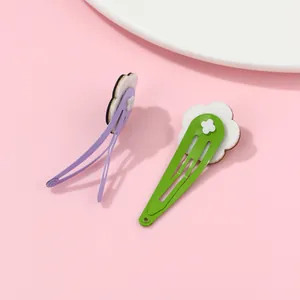 Detail of floral hair clips with white felt flowers on purple and green metal BB clips
