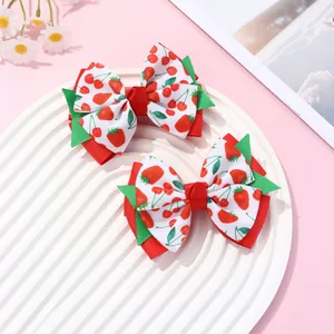 Detail shot of strawberry and cherry bow hair clips on a white tray with floral decor