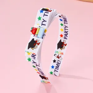 Detail of school-themed headband with bow, stars, and resin book apple ornament