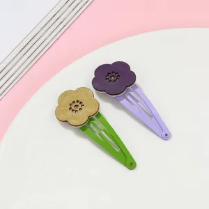 Detail of colorful hollow flower hair clips with textured leather finish and metal BB clips