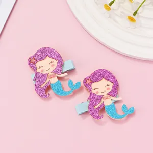 Detail of glitter mermaid hair clips with purple sequins and blue fish tail design