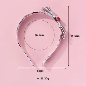 Detail view of preppy style headband with white bow and colorful cartoon patterns