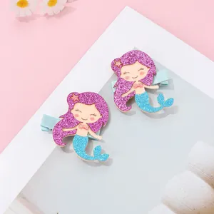 Detail of sequin mermaid hair clips with purple hair, blue tails and pink star accents