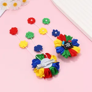 Détail de barrettes à fleurs faites main avec motif ABC d'école et glands multicolores