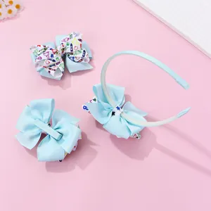 Detail of light blue bow headband and matching clips with colorful cartoon print
