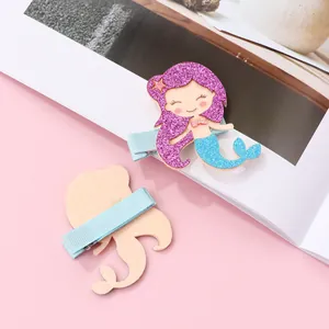 Detail of mermaid hair clips showing glitter fabric texture and ribbon wrapped metal clip