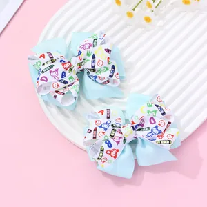 Détail de barrettes bleu clair avec motifs scolaires sur une assiette texturée blanche