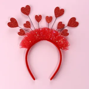 Dettaglio cerchietto rosso con cuori glitterati e tulle a pieghe per feste di bambini