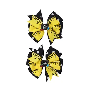 Detail of school bow hair clips with tape measure ribbon, ABC blackboard, and apple
