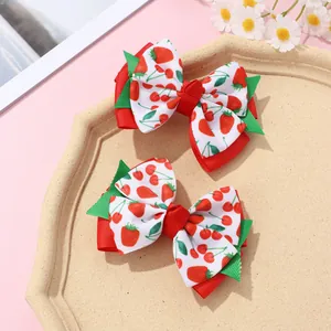 Detail of red and white double-layered ribbon hair clips with strawberry and cherry prints