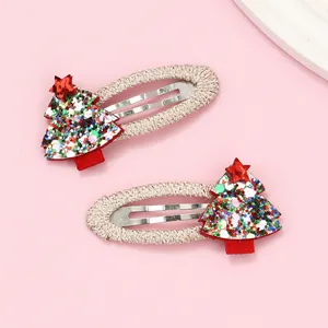 Close-up of glittery Christmas tree hair clips with sequins and gold braided wrap