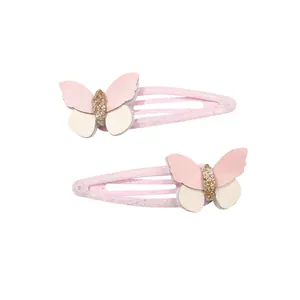 Dettaglio dei fermagli per capelli a farfalla in pelle rosa e bianca con glitter