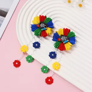 Détail de pinces à cheveux fleurs en ruban avec ardoise ABC et glands en perles
