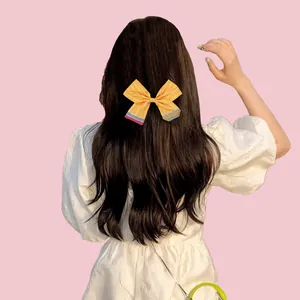 Vue arrière d'un nœud papillon crayon porté sur de longs cheveux bruns ondulés
