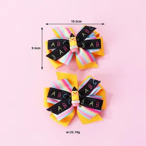 Détail de nœuds à cheveux scolaires avec rubans arc-en-ciel et petit crayon jaune