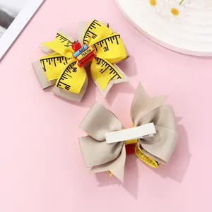 Detail of ribbon bow hair clip with school books and ruler print on fabric