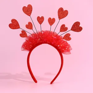 Dettaglio di pizzo a rete rosso e cuori glitterati sulla fascia festiva per bambine