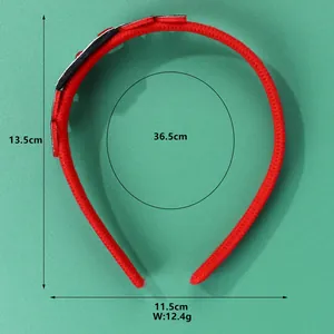 Dettaglio del cerchietto natalizio rosso in maglia con dimensioni 13,5 cm per 11,5 cm