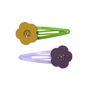 Detail of hollow floral hair clips with colorful leather petals and rhinestone centers