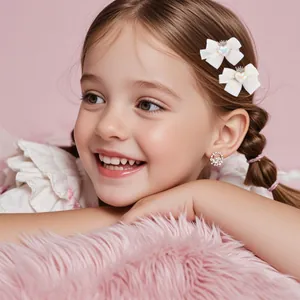Détails de barrettes à nœuds en tissu blanc avec motifs cœur et couronne sur enfant
