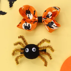 Nahaufnahme von Halloween-Haarclips mit Plüschspinne und Hexen-Schleife aus Ripsband