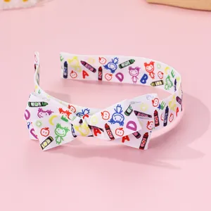 Close-up of fabric bow headband with colorful back-to-school doodle patterns for girls