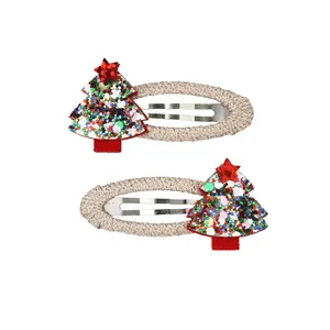 Detail of Christmas tree hair clips with colorful sequins and embroidery on white background