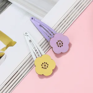 Close-up of floral snap clips with textured leather petals and golden beaded centers