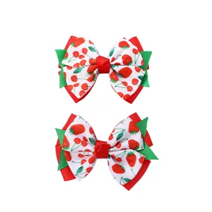 Detail showing two-piece children's hair clips with red strawberry and cherry patterns