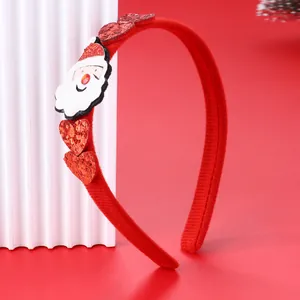 Dettaglio di un cerchietto natalizio rosso con Babbo Natale e cuori di paillettes