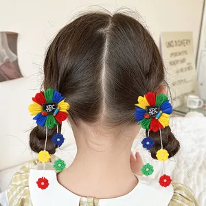 Détail de pinces à cheveux fleurs en tissu pour filles avec motifs ABC et glands colorés