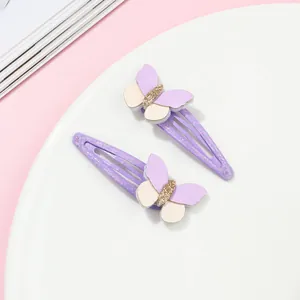 Dettaglio di fermagli per capelli a farfalla viola glitterati con paillettes e clip in metallo