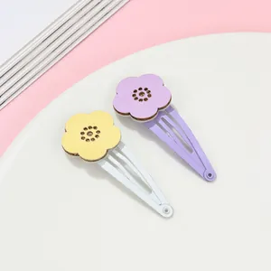 Detail of colorful hollow flower hair clips with smooth painted metal snap base