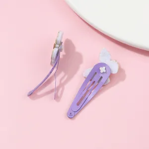 Dettaglio di fermagli per capelli a farfalla con paillettes e base BB viola