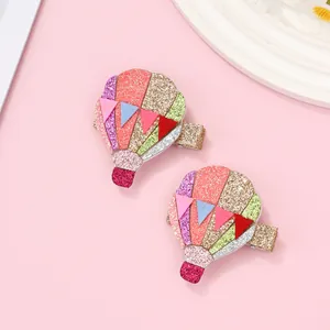 Detail of glittery hot air balloon hair clips for kids with colorful sequins decoration