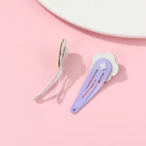 Detail of purple hollow flower hair clips with white floral petals on pink background