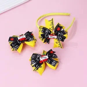 Detail of school-themed headband set with ruler pattern bows and red apple decorations