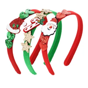 Dettaglio di tre cerchietti natalizi con motivi glitterati di Babbo Natale e bastoncini