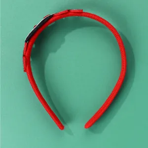 Dettaglio del cerchietto natalizio rosso con morbido tessuto e ornamenti creativi in 3D