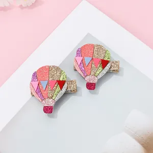 Detail of colorful glitter sequin hot air balloon hair clips for kids on pink background