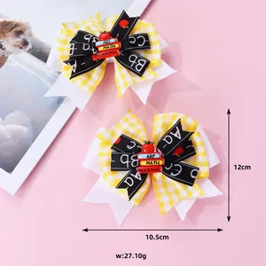 Détail de nœuds à cheveux pour la rentrée avec motifs de livres et pommes sur fond rose